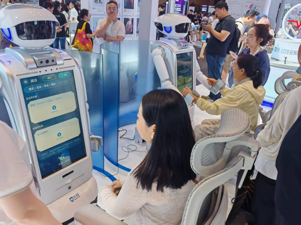 WAIC 2026 现场，参观者体验安顿中医机器人